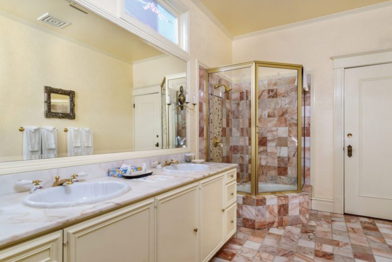 Photo of bathroom with double sinks and glass-enclosed mini-tub and shower